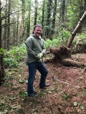 man smiling while posing in forest