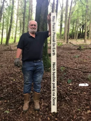 old man standing holding a message scroll